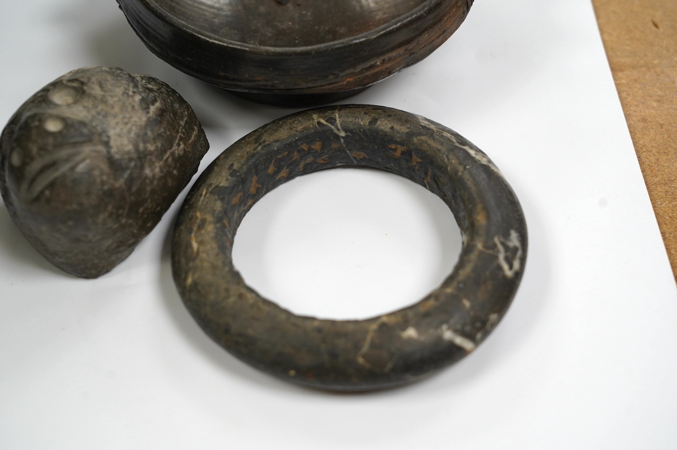 An African Dogon tribe carved stone bracelet, 10cm diameter, an Ethiopian black glazed terracotta bowl, 11cm diameter, Gurage people, and a carved black stone head of a monkey, 5.5cm, possibly North American. Condition -